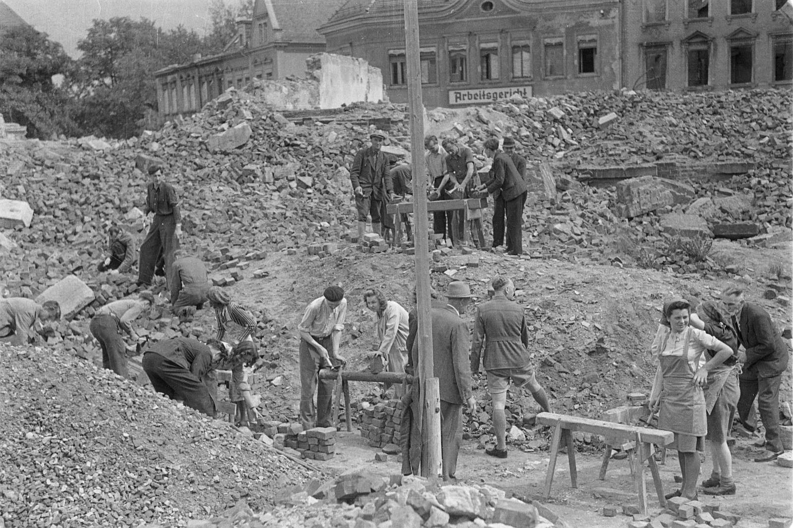 schwarz-weiß-Foto mit arbeitenden Menschen auf einem Trümmerhaufen