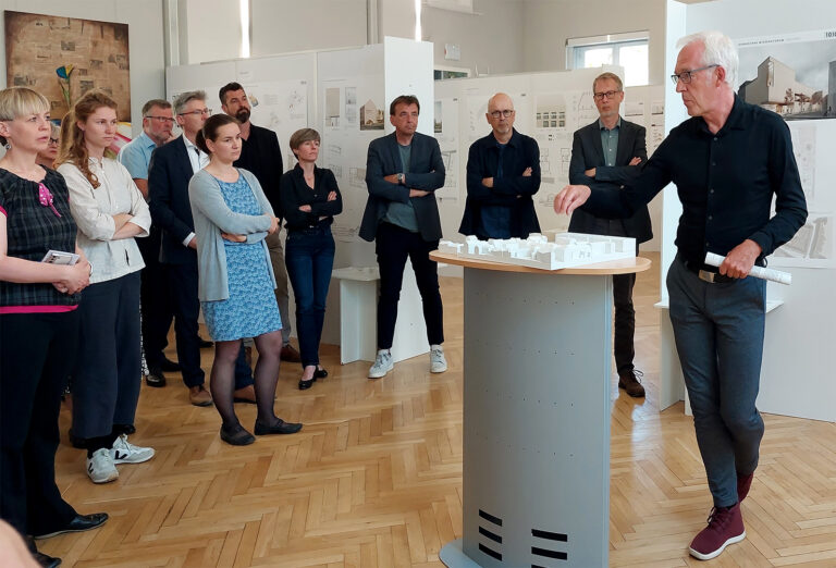 někotre wosoby steja wokoło kulowateho blida připoskaja mužej, kiž model Lawskeho areal rozkładźe
