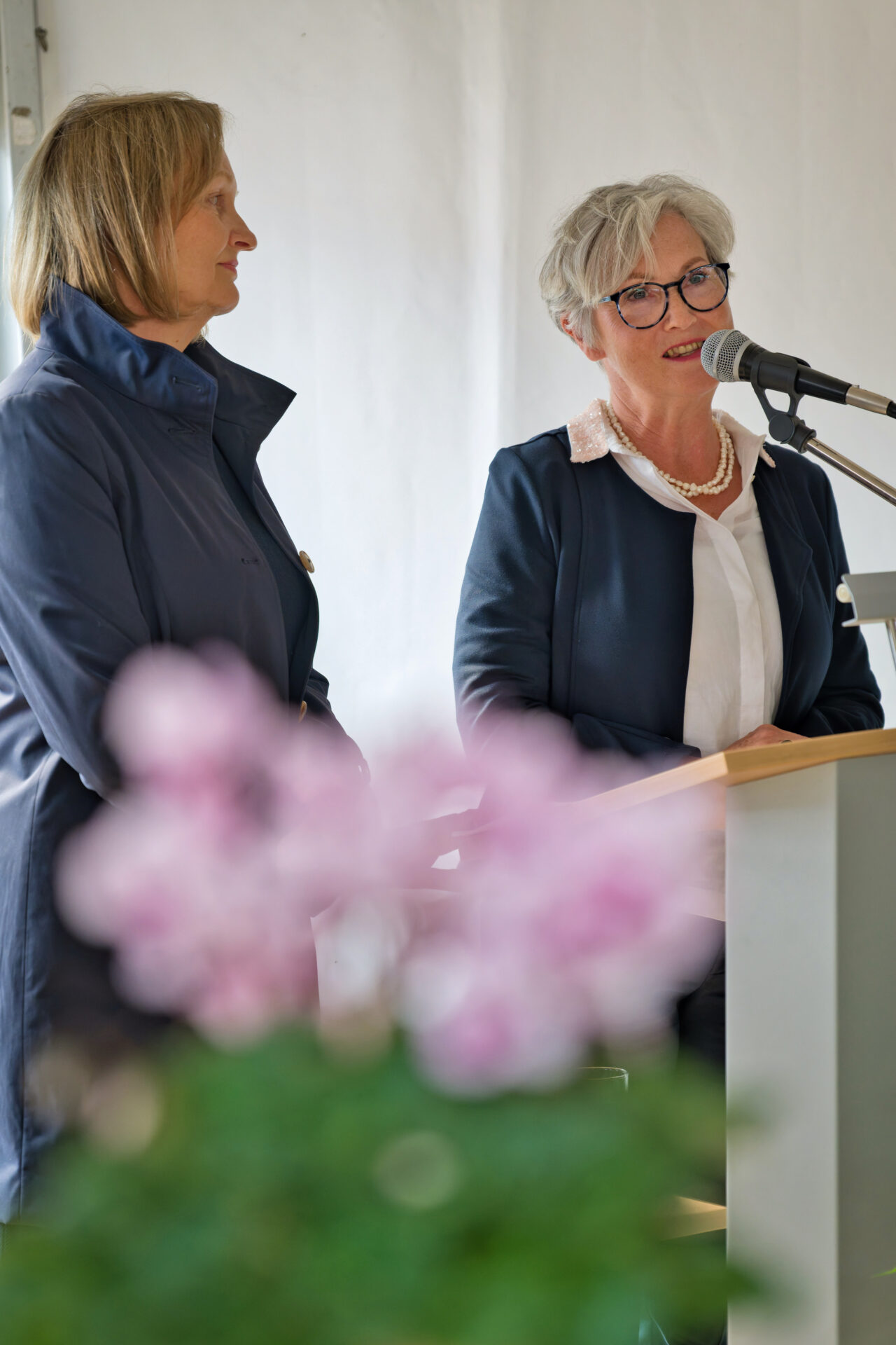 zwei Frauen an einem Rednerpult