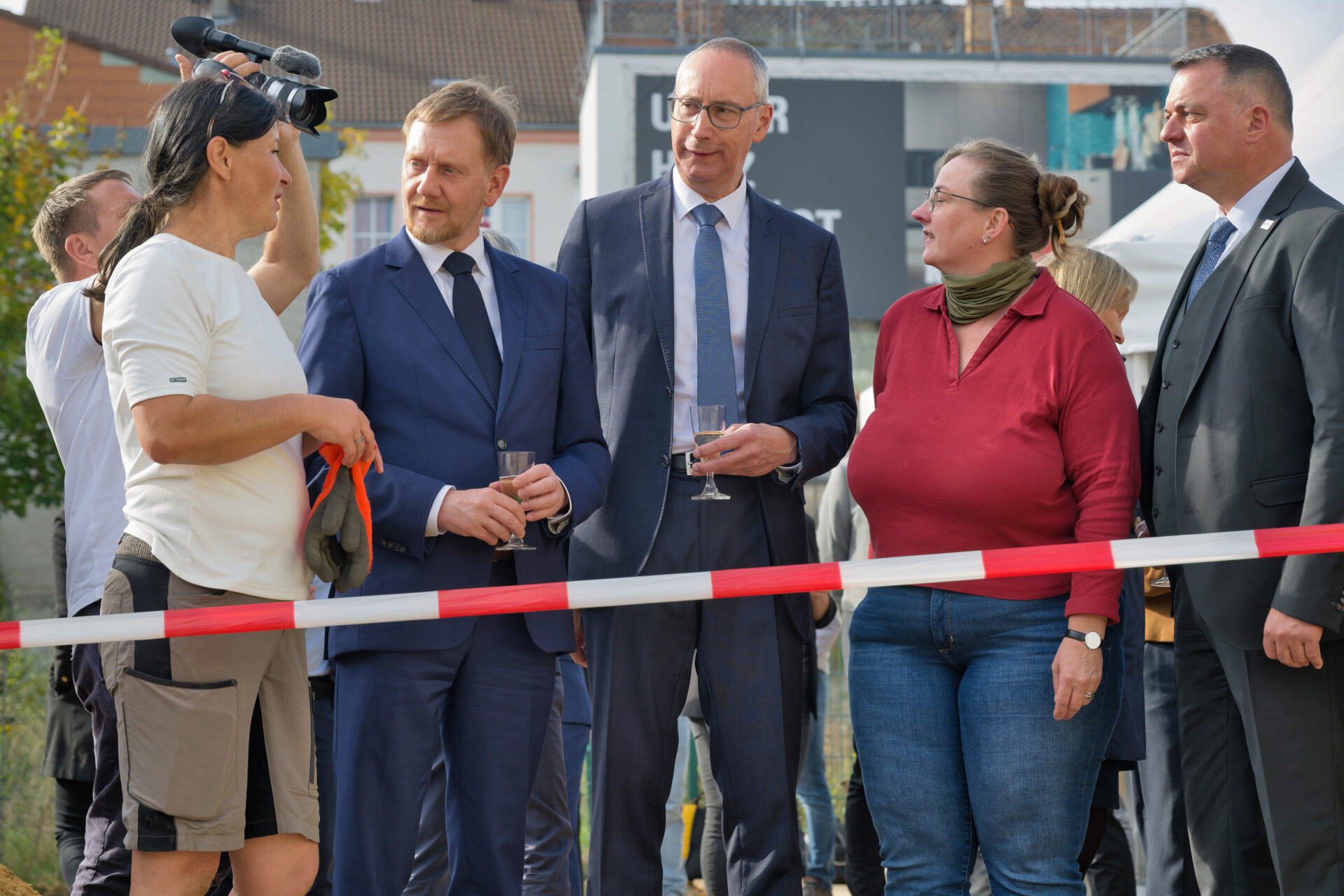 mehrere Personen stehen vor einem Absperrband